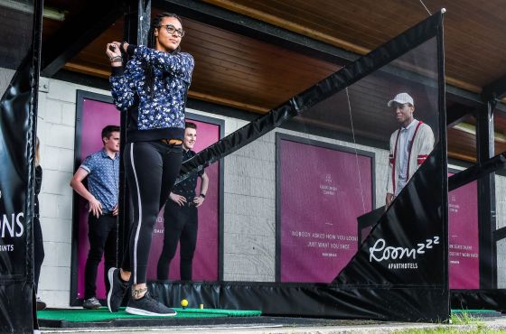 A group of golfers using the driving range.